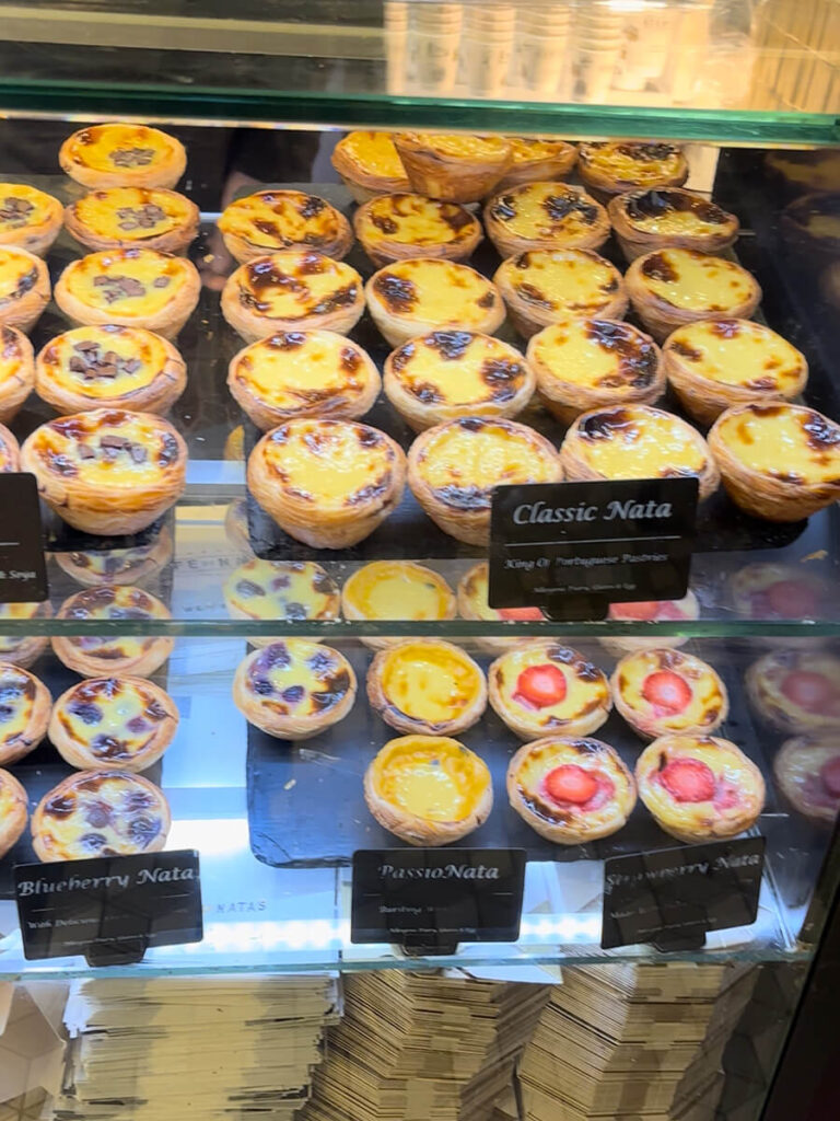 A window of Portuguese pastel de natas in Cafe de Nata in London. In addition to the classic pastel de natas, there are varieties with different toppings like strawberry, blueberry, and passionfruit
