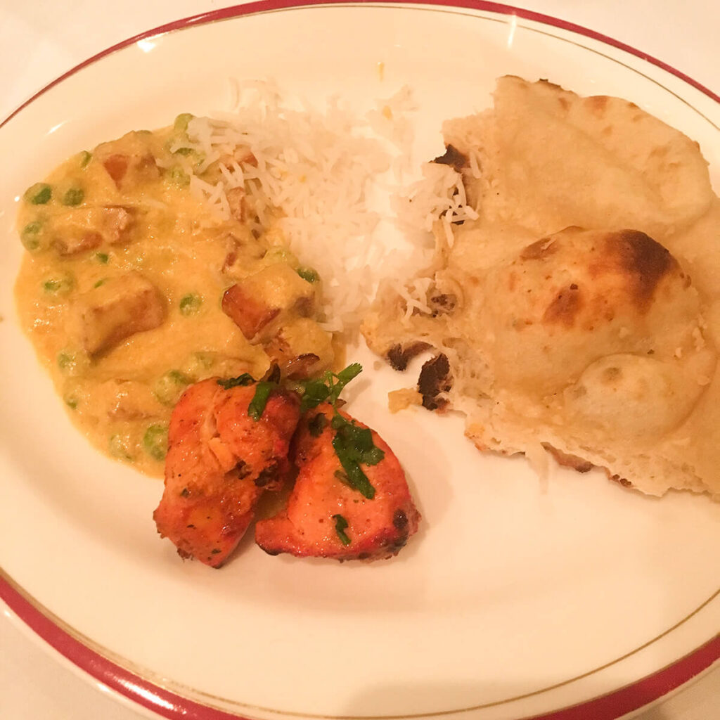 a plate of rice, chicken tandoori, naan bread, and mattar paneer, from Millbank Spice, an Indian restaurant in London