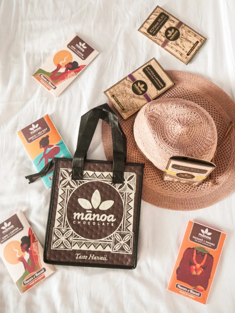 insulated bag of Manoa chocolate featuring 7 chocolate bars and a straw hat