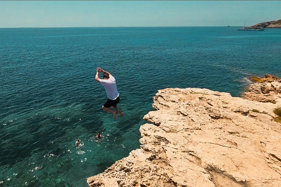Man cliff jumping in Talamanca, Ibiza, Spain