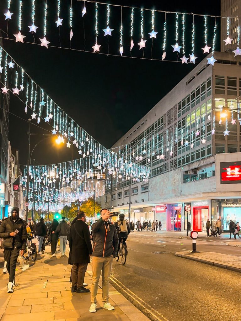 Oxford street in London at night with hanging Christmas lights and stars