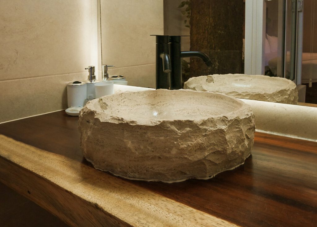 bathroom of Casa Victoria Malecon, an adults-only guesthouse in Puerto Vallarta. The bathrooms have stone vessel sinks, and soap dispensers.