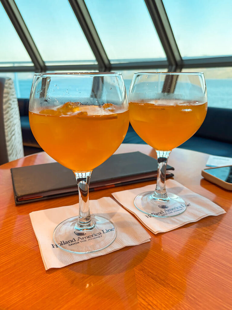 orange gin and tonics from the Orange Party on Crow's Nest on Holland America Zaandam. Behind is a view of the ocean