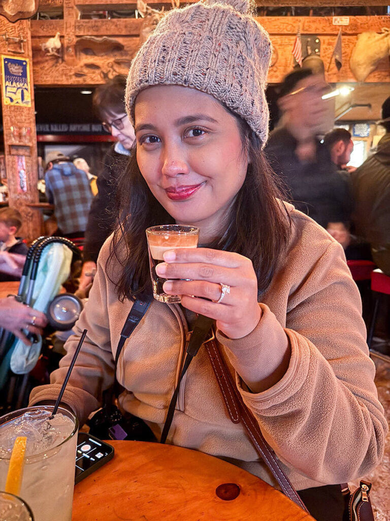 Hannah drinking a "duck fart shot" in Red Dog Saloon in Juneau, Alaska. The duck fart consists of layered equal parts kahlua, bailey's, and crown royal