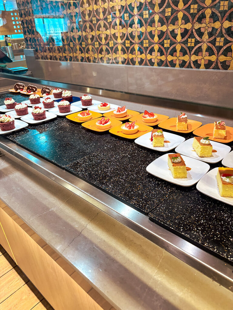 desserts in the buffet on Holland America Zaandam. Shown are cake rolls, cupcakes, strawberry cream tarts, and angel cake