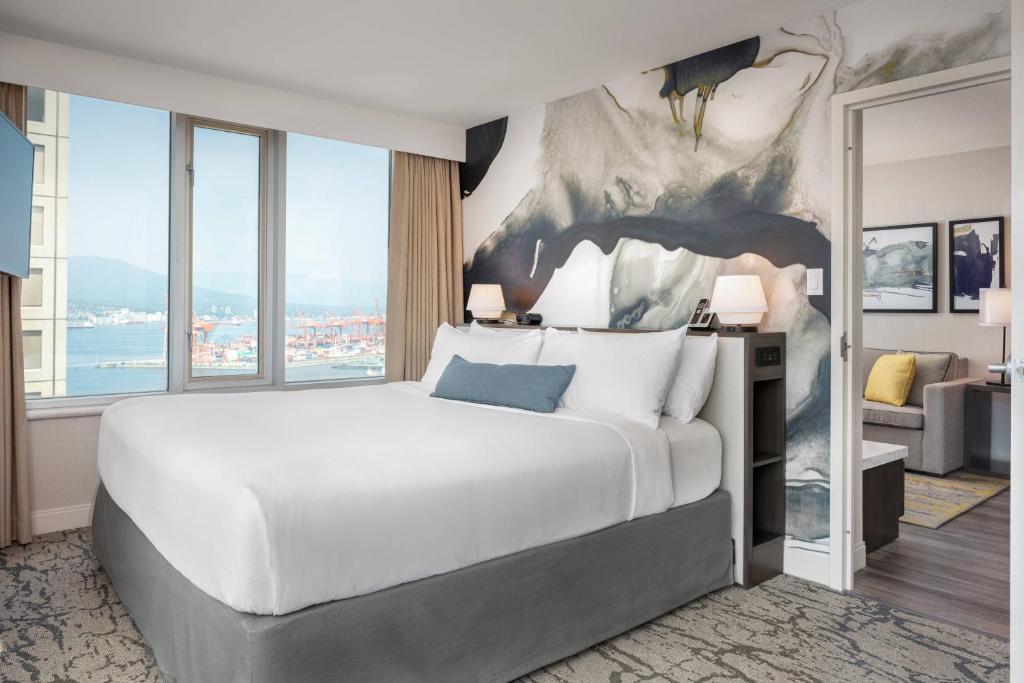 Suite with a large bed in Delta Hotels Vancouver Downtown Suites overlooking the harbor