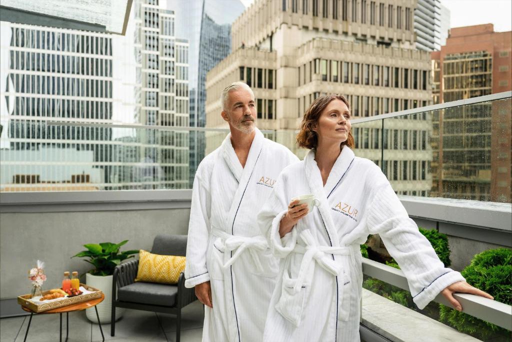An elderly couple in a white robe in a balcony with a breakfast tray in Azur Legacy Collection Hotel in Vancouver, located in Downtown Vancouver
