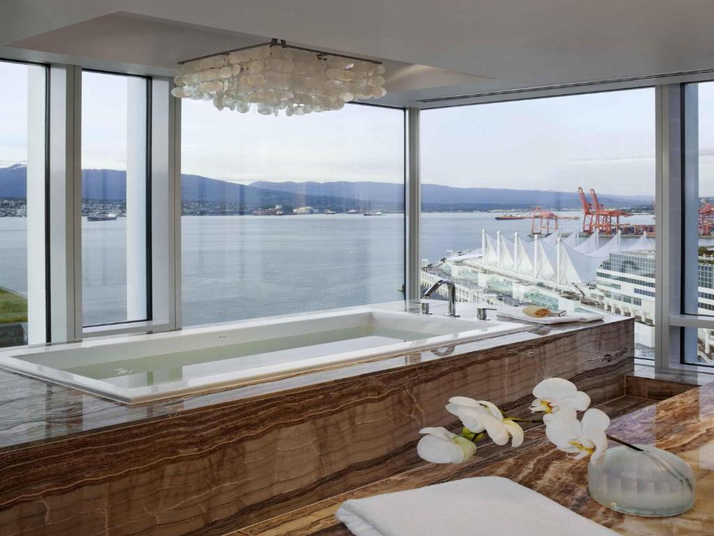 A large hot tub in Fairmont Pacific Rim in Vancouver overlooking Canada Place (the cruise terminal), the harbor, and the North Shore Mountains