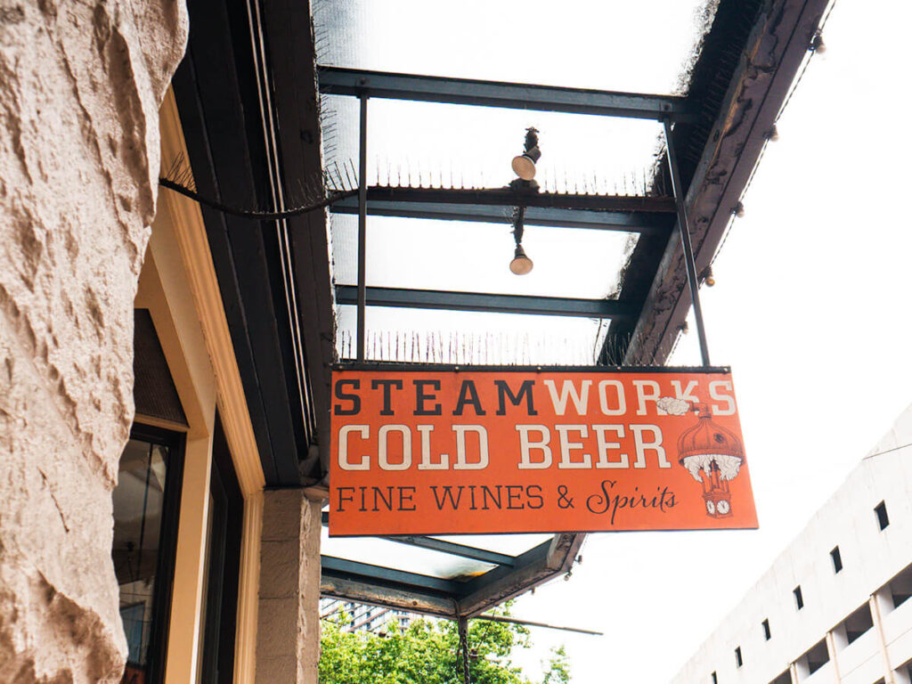 An orange sign that says "Steamworks Cold Beer, Fine Wines & Spirits", which is for Steamworks Brewing in Gastown, Vancouver