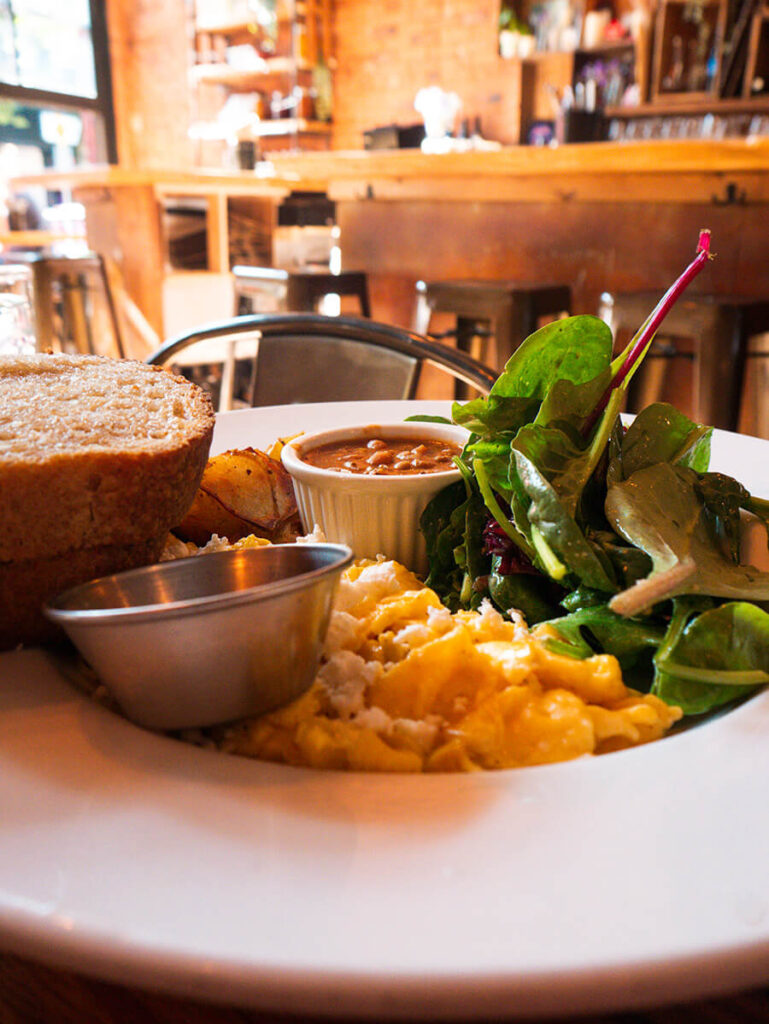 scrambled eggs, salad, bread, and beans served in a plate for brunch from Twisted Forks, a French-Canadian bistro in Vancouver