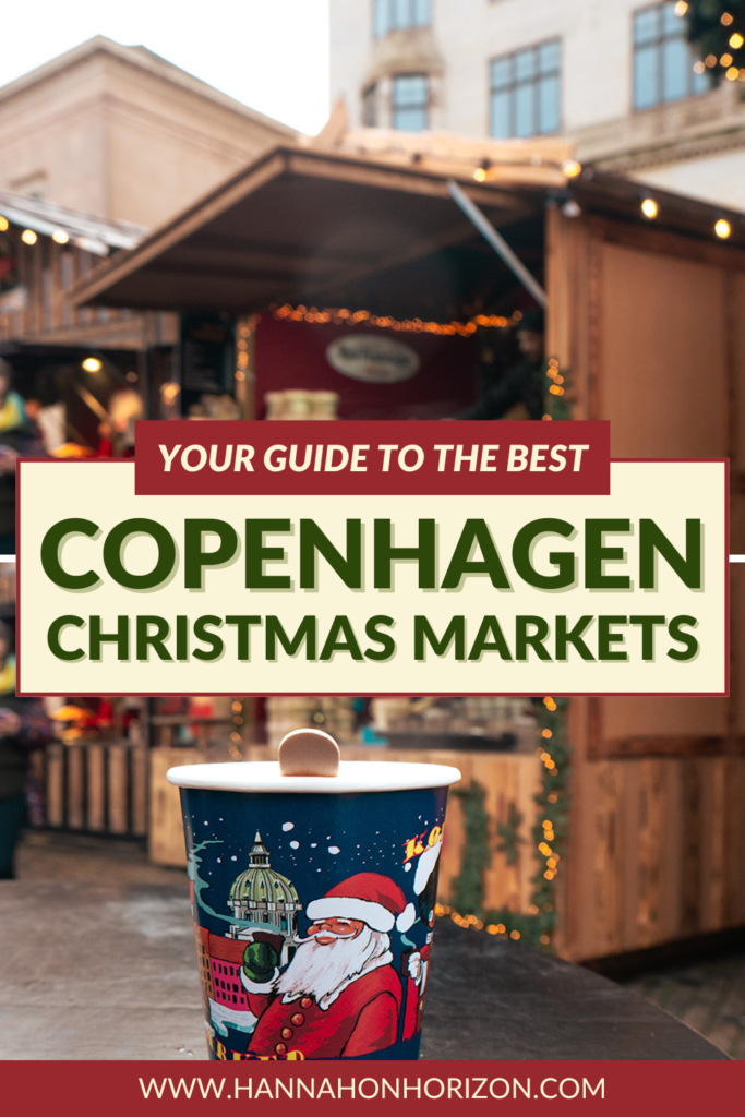Pinterest graphic with text that says "your guide to the best Copenhagen Christmas markets". Image is of A cup of glogg at the Nytorv Christmas market in Copenhagen. The cup is dark blue with an image of santa, and right behind the cup is a wooden stall