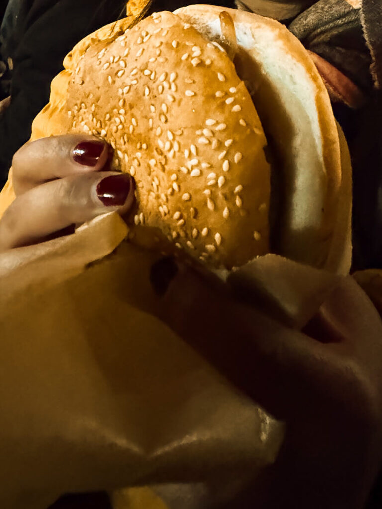 Hannah holding an elk burger at the Bergen Julemarked