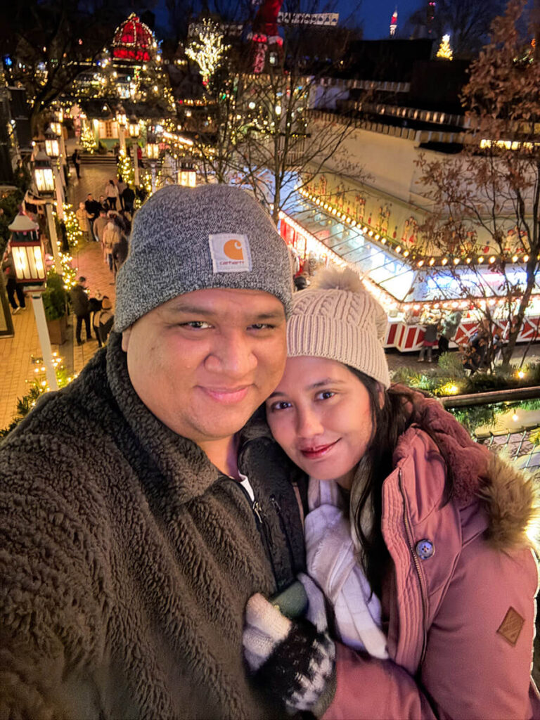 Hannah and Cecilio at Tivoli Gardens in Copenhagen at night with Christmas lights