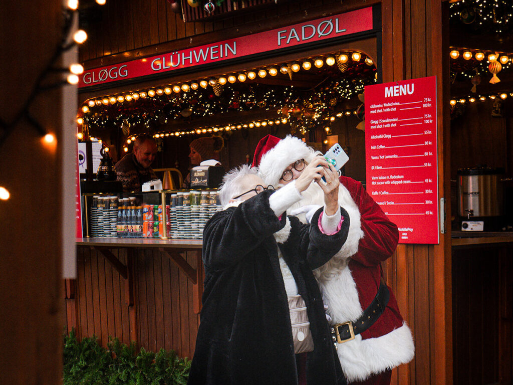 A woman taking a selfie with Santa at the Hans Christian Andersen Christmas market in Copenhagen