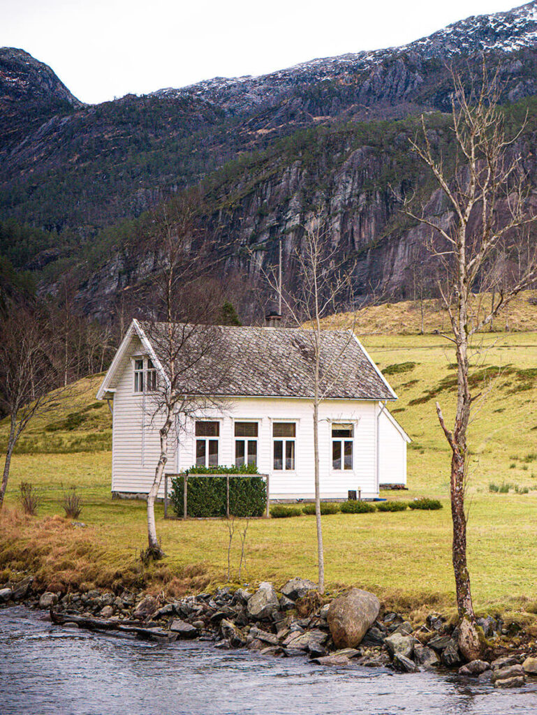 a white house that used to be a school, but is now a museum, off the Mostraumen Strait in Norway
