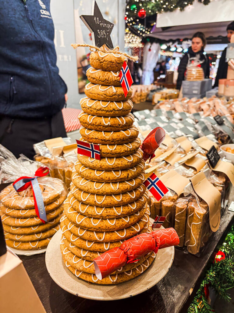 A stall at the Bergen Christmas market selling wreath cake, with the Norway flags attached to it